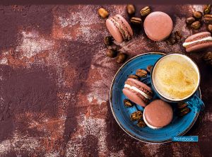Cup of coffee, chocolate macaroons and coffee beans on a brown background