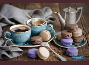 Coffee pot, teal cups with black coffee and macaroon pyramid on a wooden table