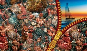 Underwater red pebbles rocks with a sailing boat