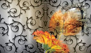 Decorative iron grill with orange flower and tree on a steel background