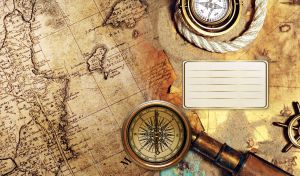 Vintage compasses, an antique telescope and golden ship's helm on an old sepia map