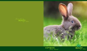 Young grey rabbit in the grass against olive and green backdrop