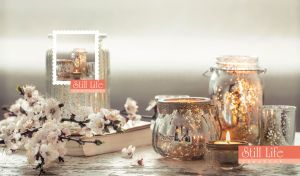 Still life composition of silver jars and sakura arranged in soft grey tones
