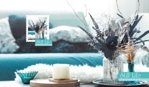 Still life composition of dried flowers and glass jars arranged in soft teal tones