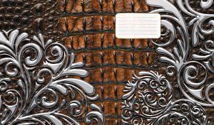 Silver swirl ornament stencil on brown leather texture