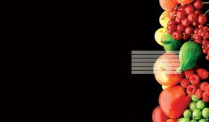 A bunch of colorful fruits arranged vertically to the right on a black background