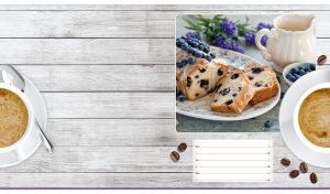 Pound cake and blueberries on a light gray wooden backdrop with a coffee cup