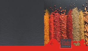 Arrangement of herbs and spices on a black tabletop with a red footer