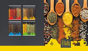 Arrangement of herbs and spices on a black tabletop with a yellow footer