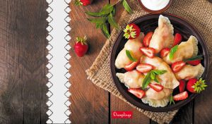 Delicious dumplings with fresh strawberries and mint on a wood-textured backdrop
