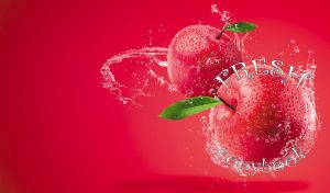 A pair of fresh red apples in water splashes on red