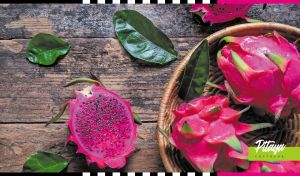 Composition of fresh pitayas in a wicker basket on a brown wooden table