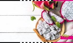 Composition of sliced and cubed pitayas on a white wooden table
