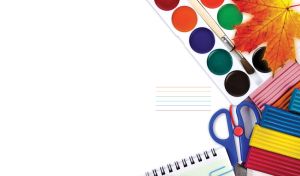 Watercolor paints and other school stationery on white backdrop with a fall leaf