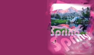 Spring lake with snowy mountains, large rocks and green grass in the foreground