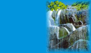 Majestic waterfall flows down the large rocks covered in moss in the daylight