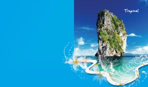 Huge rock covered with green in the calm sea on blue