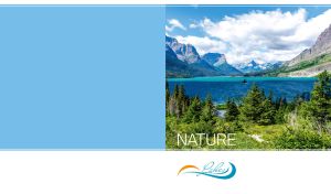 Lake in the shades of blue in sunlight against the mountains beneath the clouds