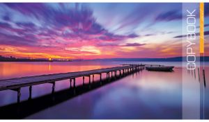 A boat by the long wooden pier against the purple-blue sunset