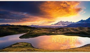 Alpine lake and snowy peaks at orange-blue golden hour