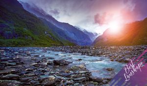 Best landscape with the sun in the purple-blue sky shining on a rocky stream