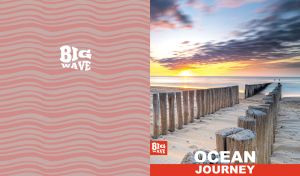 Wooden beach poles lining a peaceful sand shore at sunrise on pastel red