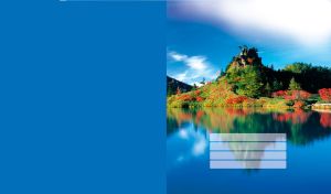 Blue lake and green hill, with yellow red bushes, reflected in the water on blue