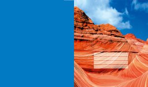 Picturesque red canyon rocks with blue little cloudy sky, on a blue background