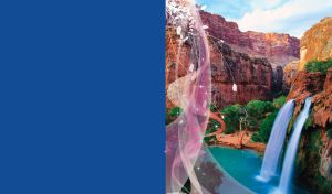 Canyon waterfall falls into the blue rive with trees on the riverbank