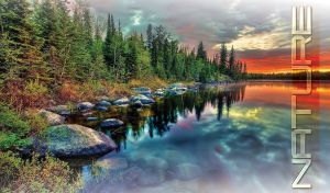 Green spruces and gray boulders on the shore of a teal forest lake at dusk