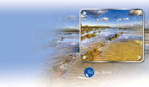 Grey clouds in the blue sky float over a rocky beach in a frame with rivets
