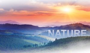 Fading orange light of the setting sun over a pastel purple valley