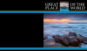 Smooth stones washed by foamy ocean waves on black