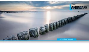 Wooden breakwater in the grey sea at dawn on white