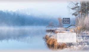 Late autumn landscape with frosty trees and grass by a pastel blue foggy river