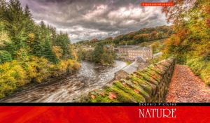 Scottish town on the bank of the River Clyde by autumn woods against a grey sky