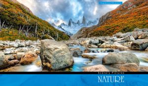 Mountain river flowing under boulders against a lush forest under a cloudy sky