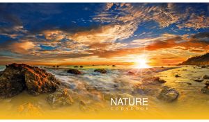 Panoramic scene of foamy waves on a rocky shore at a golden dawn