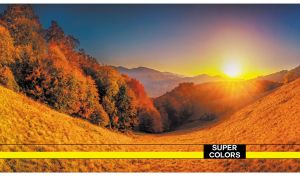 Mountainous landscape with a sun rising over the bright orange valley