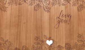 Wood burning art depicting a floral edge design on a beige wooden texture