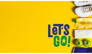 Sneakers, water bottle and green apples on a yellow backdrop