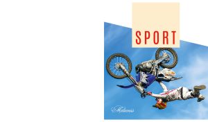 A motorcyclist executes a somersault against a blue sky