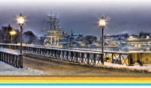Evening river bridge and moored ships by the winter river in Stockholm