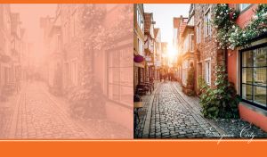 Sunset lights up a narrow street with brick buildings and street cafes in Bremen