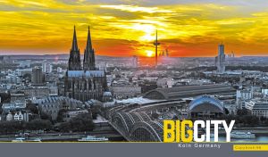 An aerial panoramic view of Koln, Germany against the yellow orange sunset sky