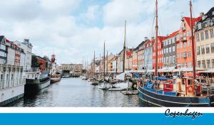 Scenic view of colorful houses and boats lining the Copenhagen harbor by day