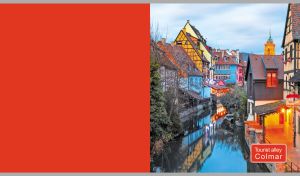 An atmospheric view of Colmar with illuminated old buildings on a red backdrop