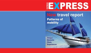 White sailing ship with blue sails on the cover of a travel magazine