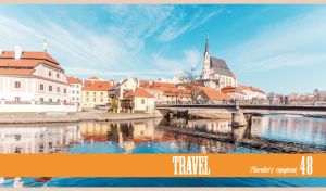 St Vitus cathedral and the red roofs of Cesky Krumlov under the light blue sky
