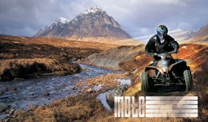 Quad rider at an off road ATV motocross event in river and mountains